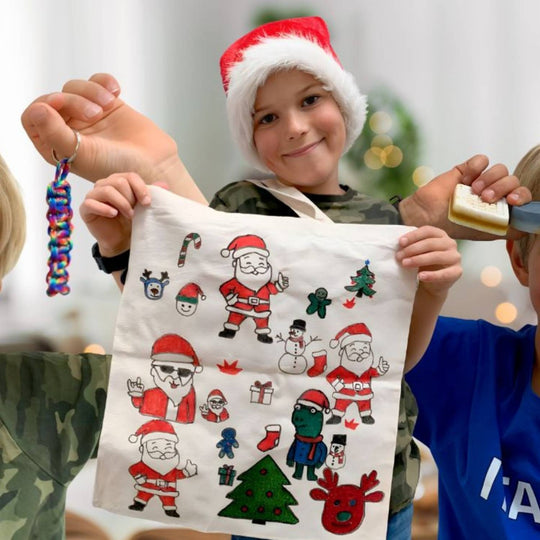 En dreng viser stolt de hjemmelavede julegaver, han har skabt med FabiBoks.